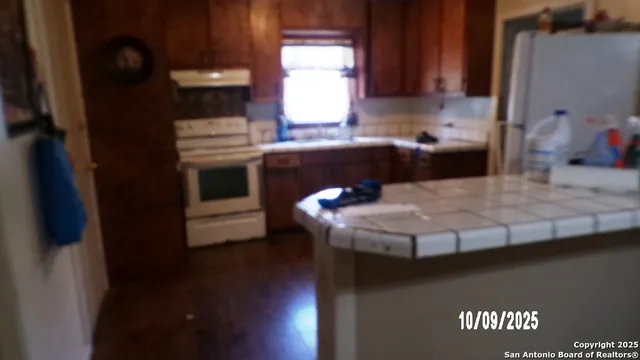 a kitchen with a sink a stove and cabinets