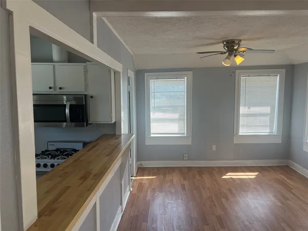 a view of a kitchen with a stove wooden cabinets and a window