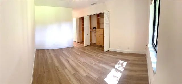 a view of empty room with wooden floor