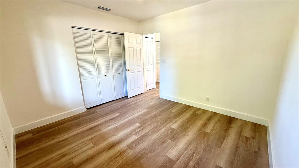 110 Northwest 70th Street, Unit 202 Boca Raton, FL 33487 - Photo 7 of 13 a view of an empty room with wooden floor