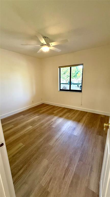 110 Northwest 70th Street, Unit 202 Boca Raton, FL 33487 - Photo 8 of 13 an empty room with wooden floor and windows