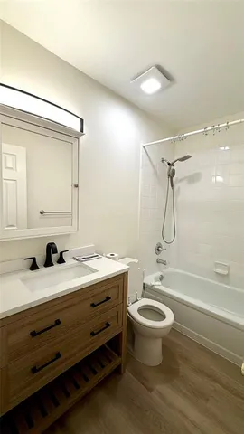 a bathroom with a double vanity sink toilet mirror and shower