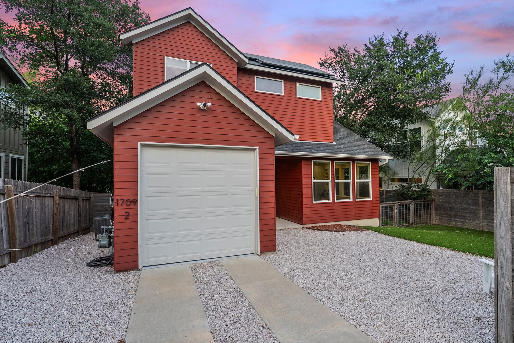 1709 Perez Street, Unit 2 Austin, TX 78721 - Photo 4 of 33 Bold red siding and a crisp white garage door highlight this contemporary home's welcoming exterior.
