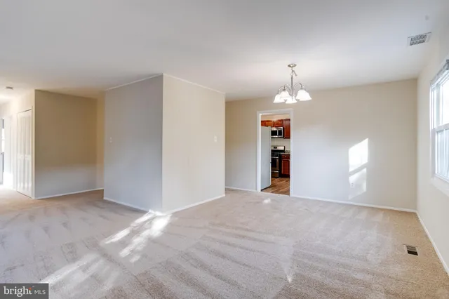 an empty room with windows and fireplace