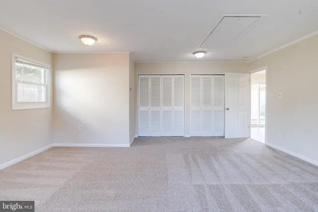 an empty room with windows and closet