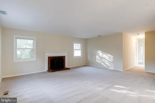 a view of an empty room with window and fire place