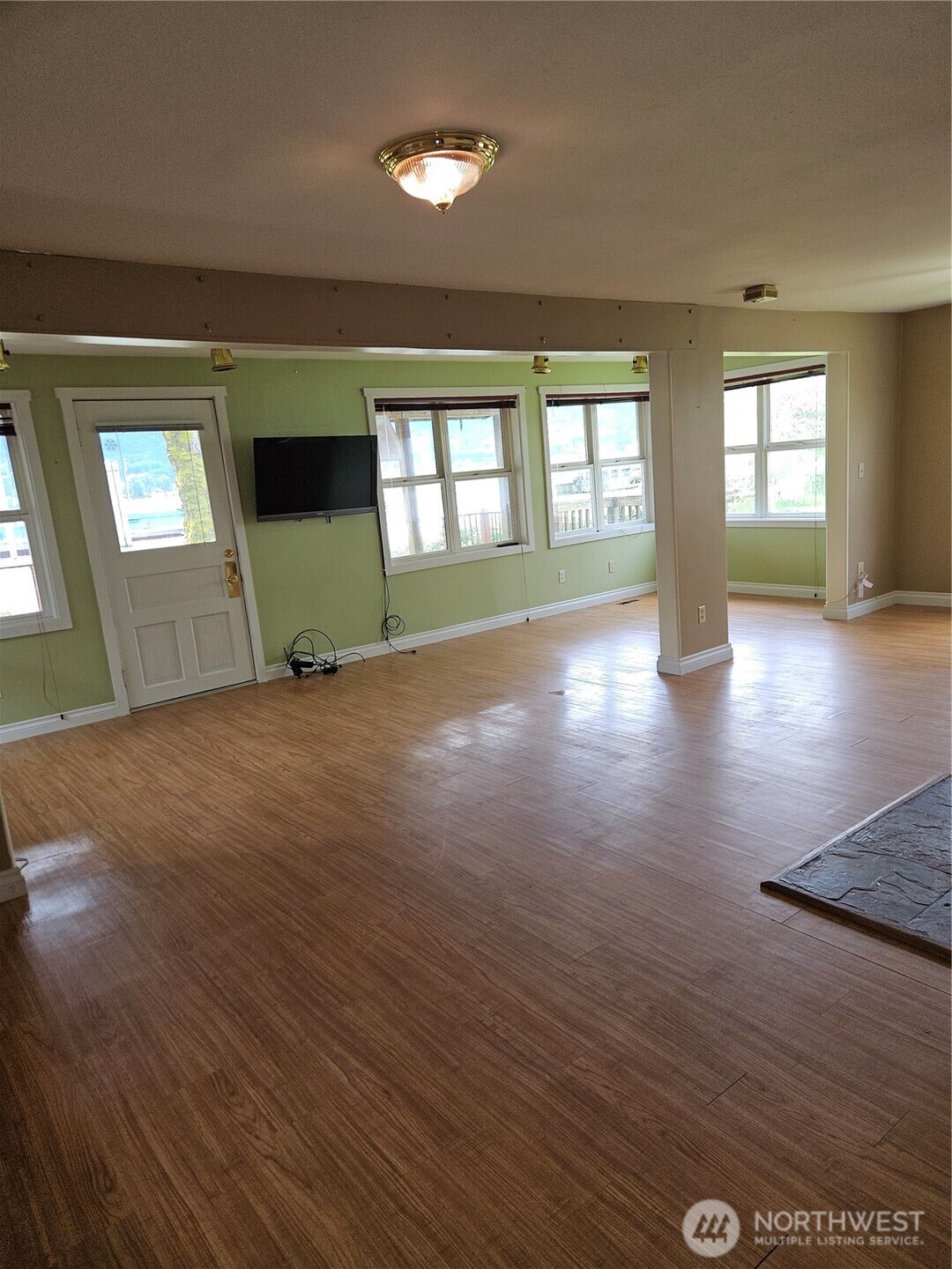 20 East Sunny Sands Road Cathlamet, WA 98612 - Photo 4 of 19 an empty room with wooden floor and windows