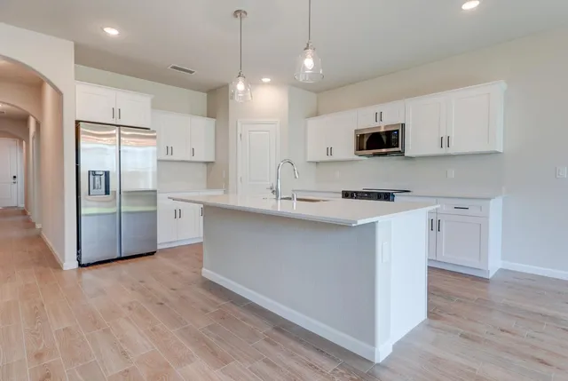 a kitchen with stainless steel appliances a refrigerator sink and microwave