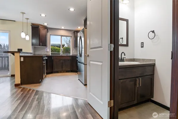 a kitchen with kitchen island granite countertop a sink appliances and cabinets