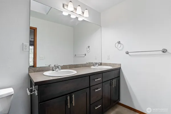 a bathroom with a granite countertop sink a toilet and a mirror