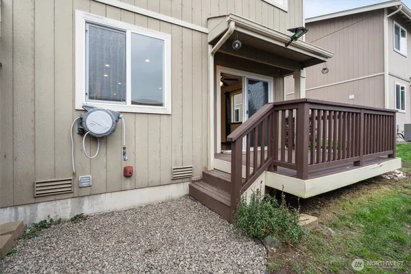 a view of a house with wooden deck and furniture