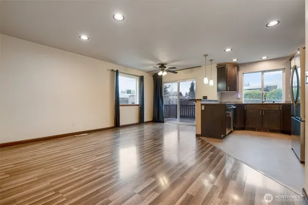 a large hall with stainless steel appliances granite countertop a large counter top a sink and a refrigerator