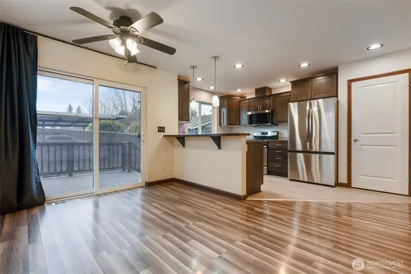 a view of a kitchen with stainless steel appliances wooden floor and a large window