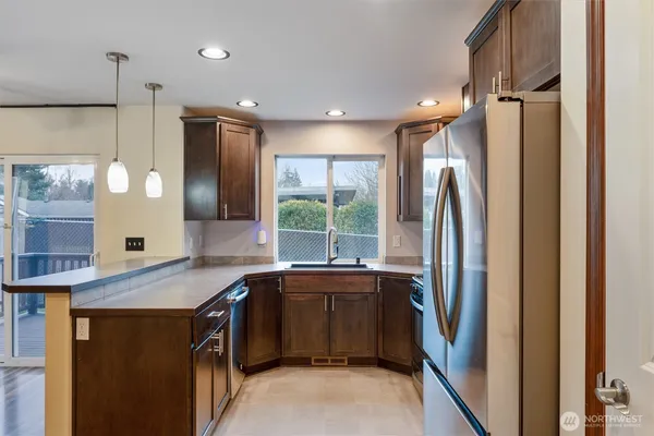 a kitchen with stainless steel appliances granite countertop a refrigerator and a sink