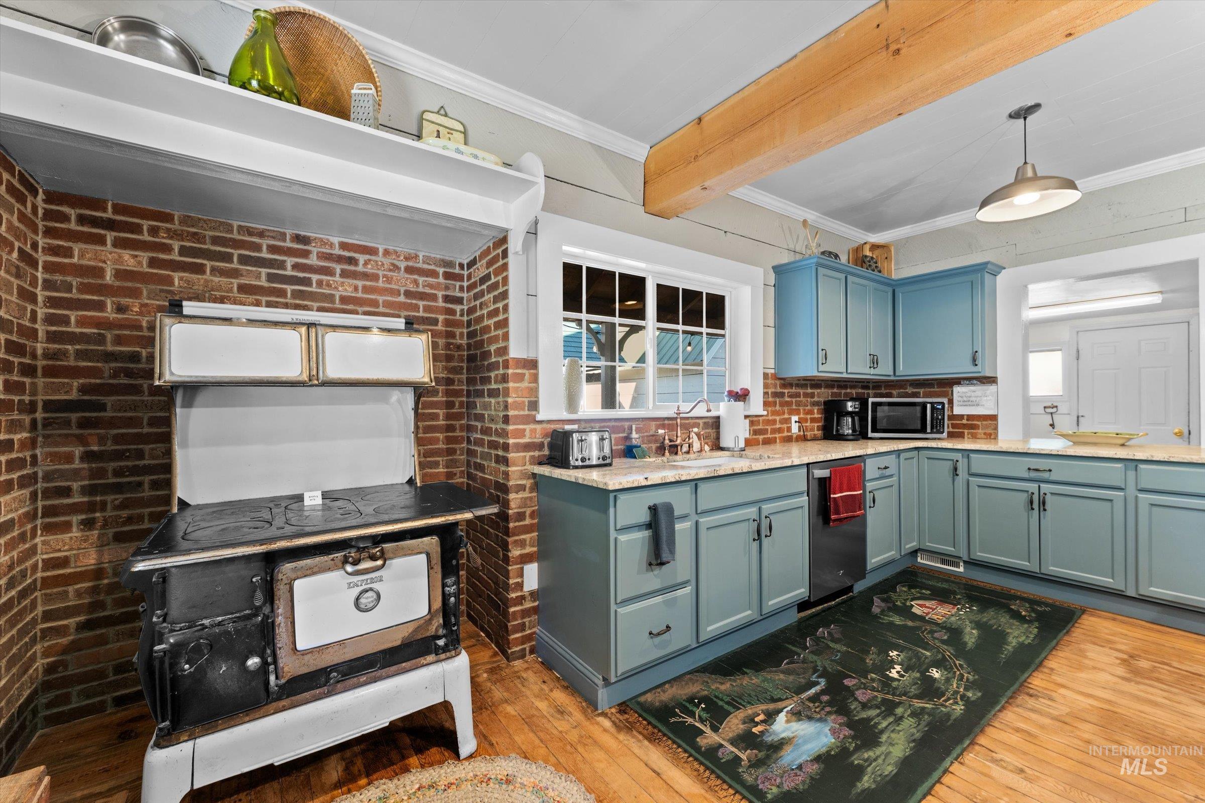 315 South Middlefork Road Garden Valley, ID 83622 - Photo 15 of 49 Kitchen with light wood-style flooring, crown molding, pendant lighting, light stone counters, and appliances with stainless steel finishes