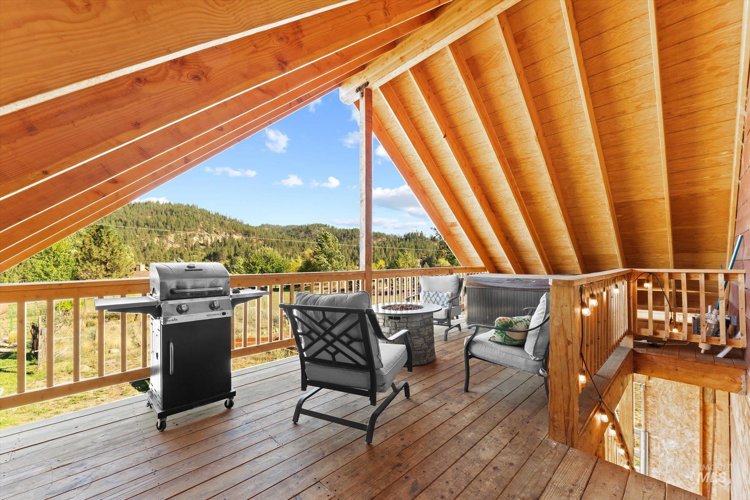 315 South Middlefork Road Garden Valley, ID 83622 - Photo 26 of 49 Deck featuring a wooded view, an outdoor fire pit, and a grill