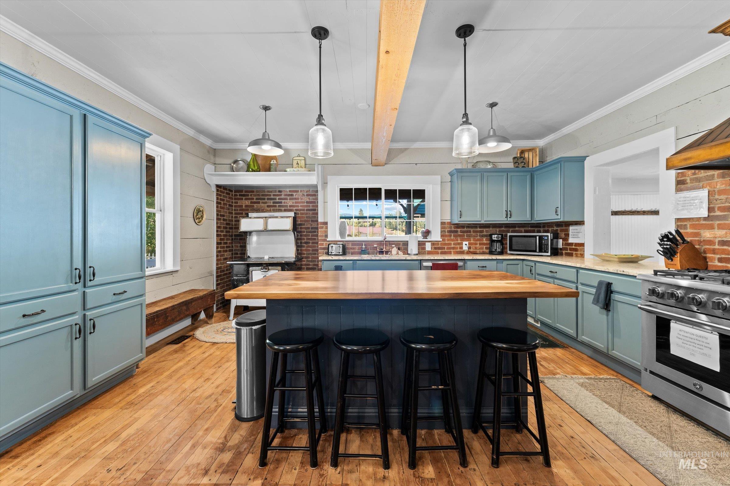 315 South Middlefork Road Garden Valley, ID 83622 - Photo 10 of 49 Kitchen with light wood finished floors, a kitchen island, hanging light fixtures, a kitchen bar, and stainless steel appliances