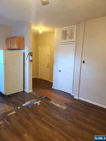 a view of a room with wooden floor and a bathroom