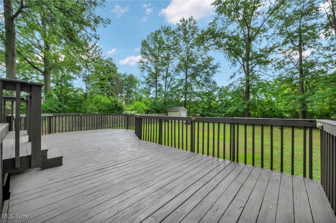 47655 Cooper Foster Park Road Amherst, OH 44001 - Photo 48 of 49 Deck with a storage unit, a yard, and view of scattered trees