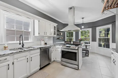 a kitchen with stainless steel appliances granite countertop a stove a sink and a refrigerator