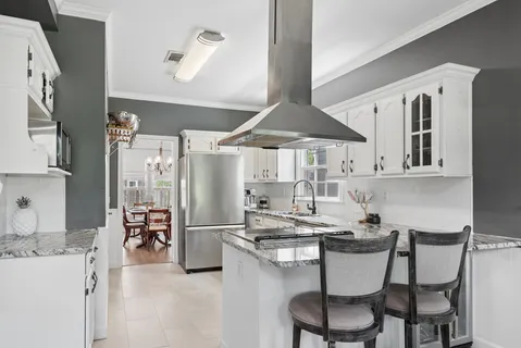a kitchen with stainless steel appliances kitchen island granite countertop a sink and cabinets