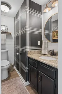 a bathroom with a granite countertop sink and toilet