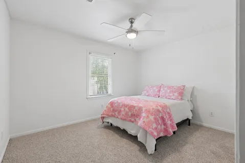a bed room with a bed and a ceiling fan
