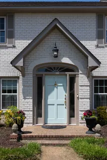 a front view of a house with a yard and potted plants
