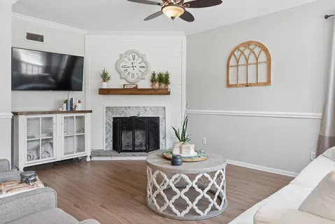 a living room with furniture a flat screen tv and a fireplace