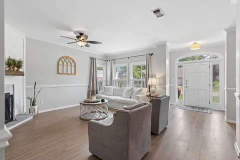a living room with furniture a window and wooden floor