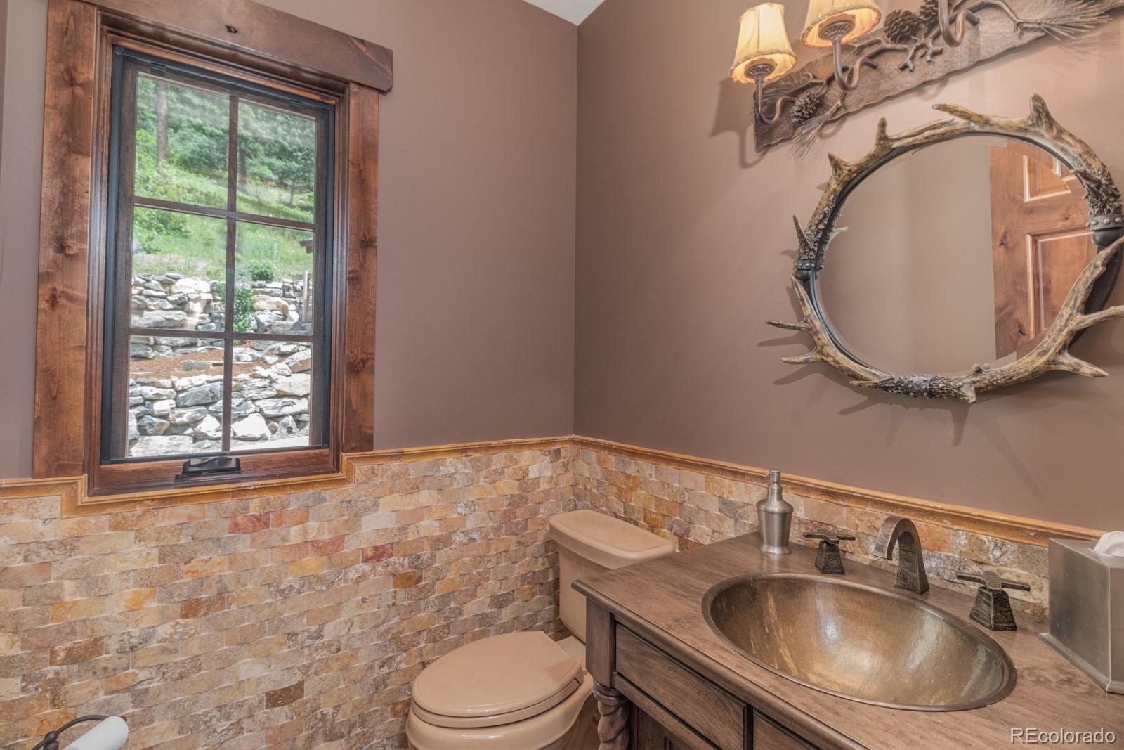 30 West Ranch Trail Morrison, CO 80465 - Photo 17 of 40 a bathroom with a toilet sink and mirror