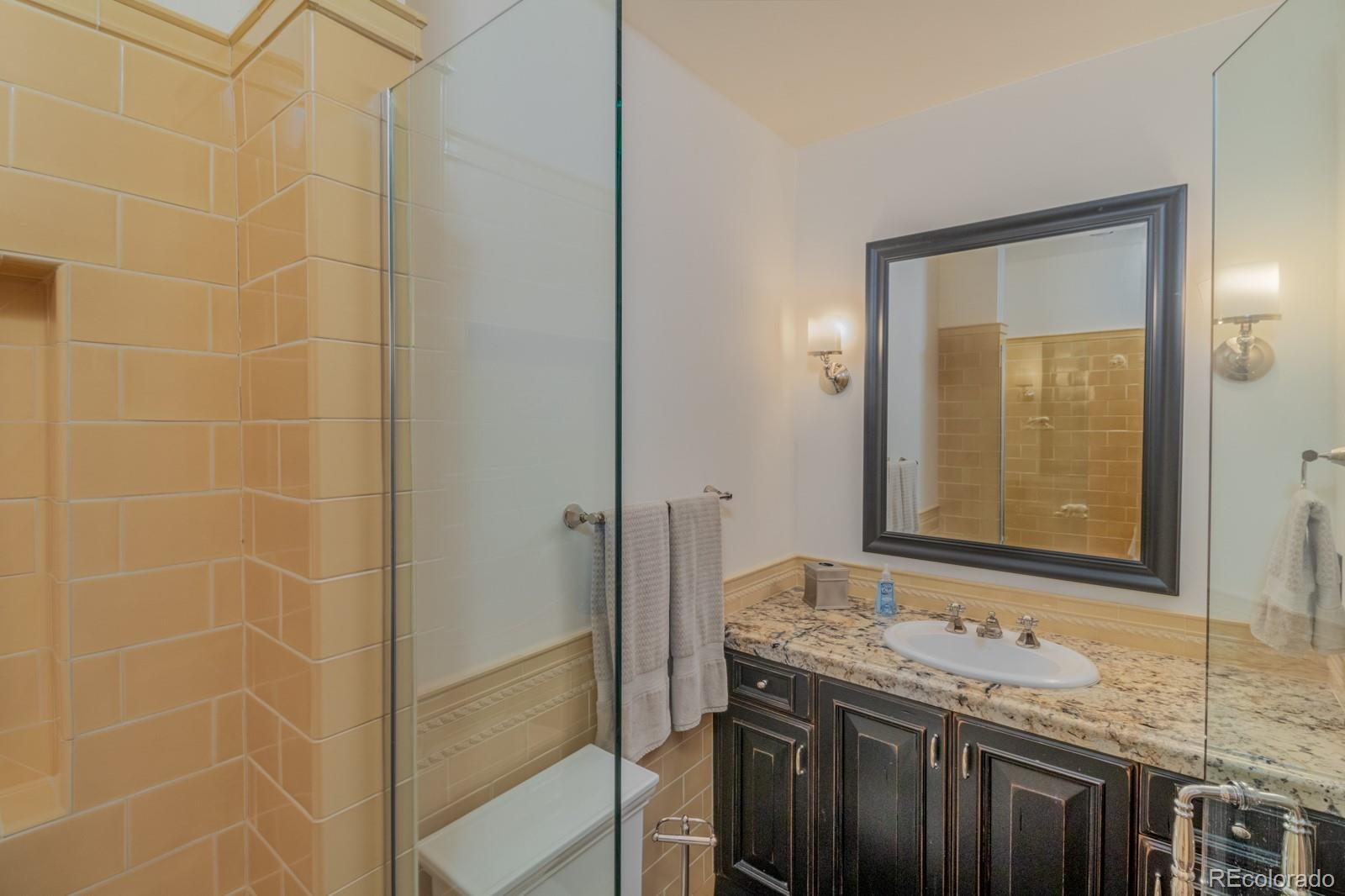 30 West Ranch Trail Morrison, CO 80465 - Photo 26 of 40 a bathroom with a granite countertop sink and a mirror