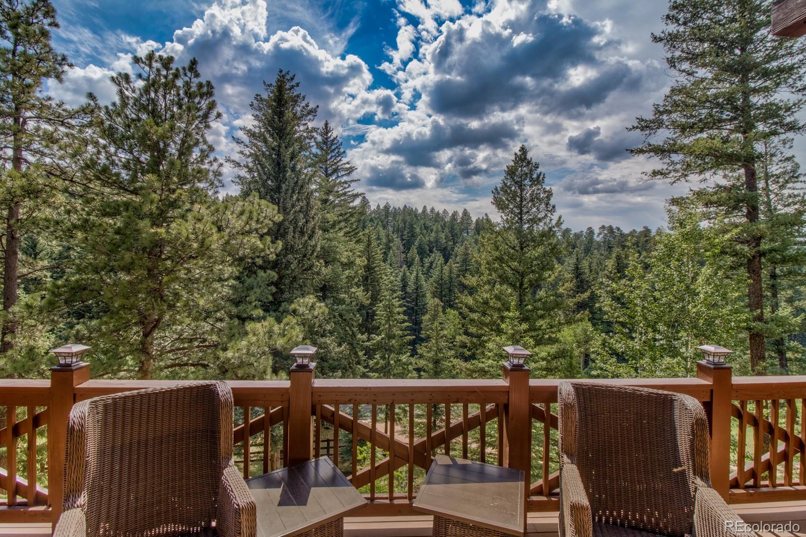 30 West Ranch Trail Morrison, CO 80465 - Photo 34 of 40 a view of a roof deck with table and chairs with wooden floor and fence