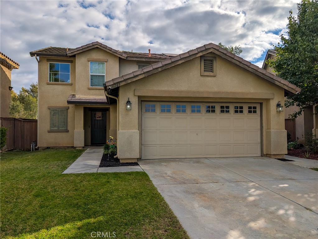 3215 Canna Way Perris, CA 92571 - Photo 1 of 1 a front view of a house with a yard and garage
