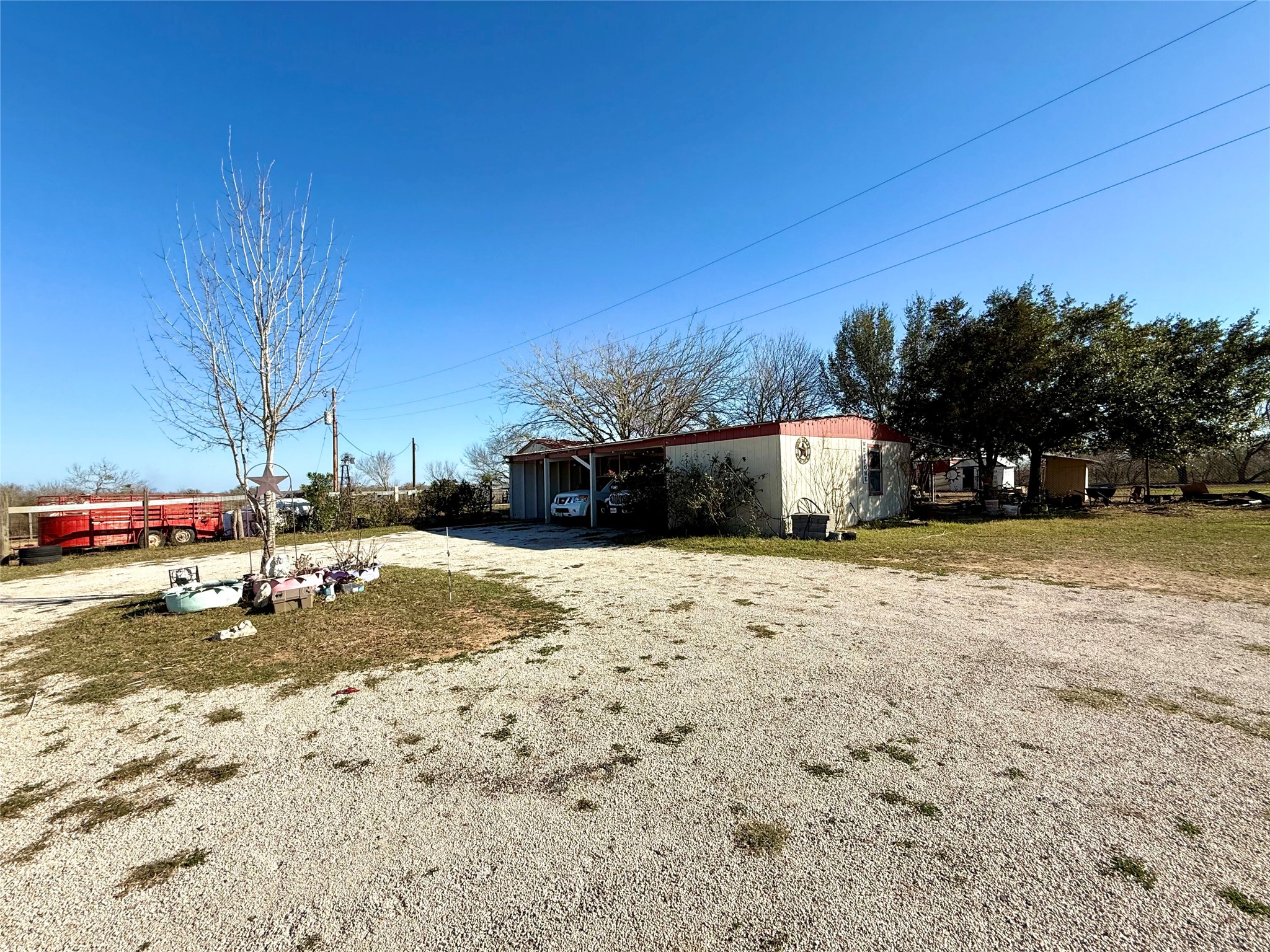 View of front of home featuring a pole building, an outbuilding, and driveway