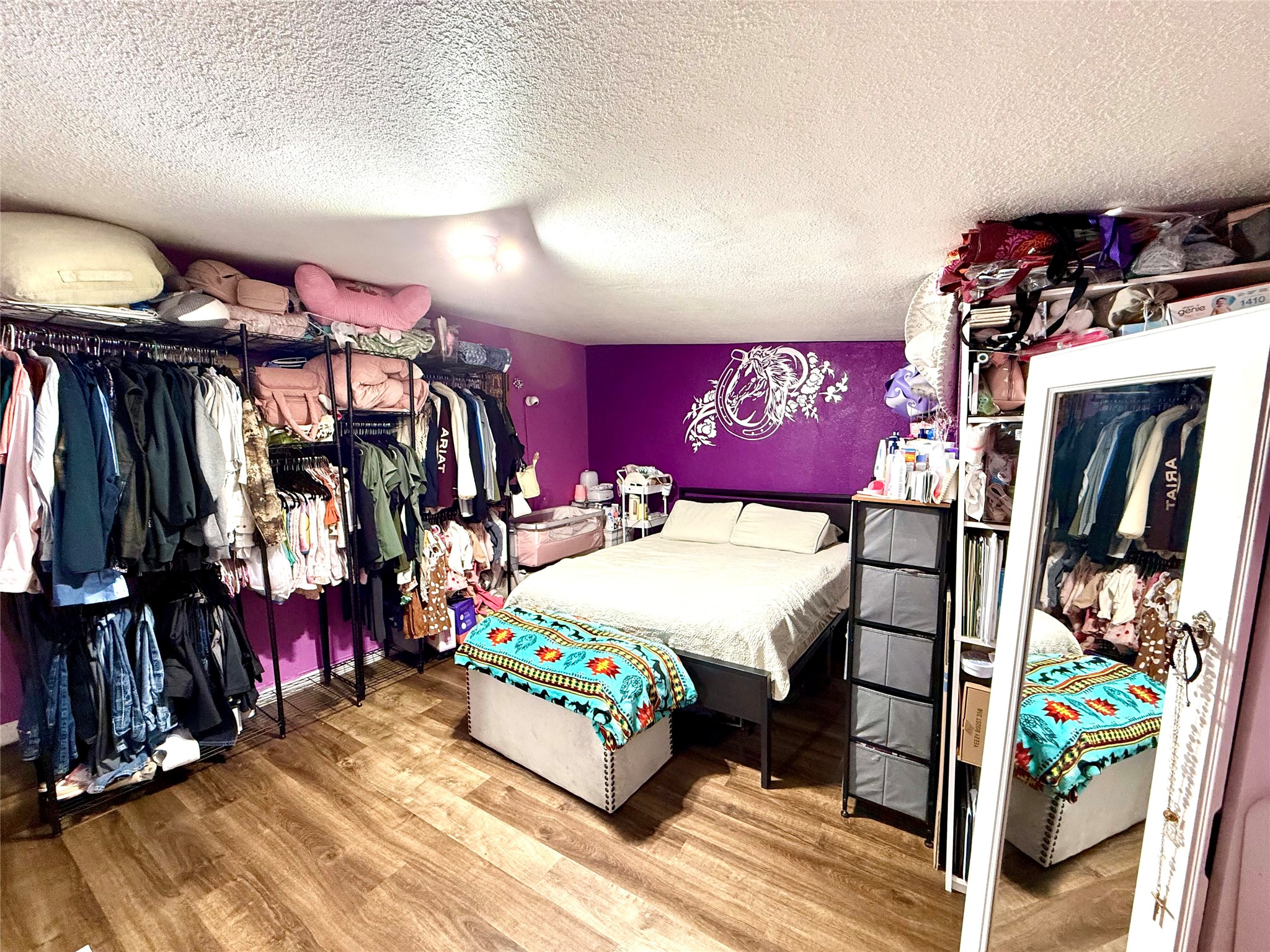 685 Fox Lane Lockhart, TX 78644 - Photo 10 of 39 Bedroom featuring wood finished floors, a textured ceiling, and a closet. Extra added room