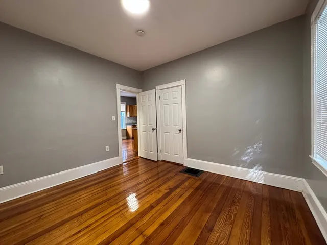 a view of an empty room with wooden floor