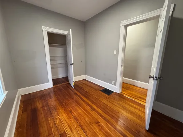 an empty room with wooden floor and entrance