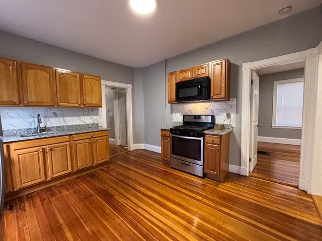 a kitchen with granite countertop a stove top oven and sink