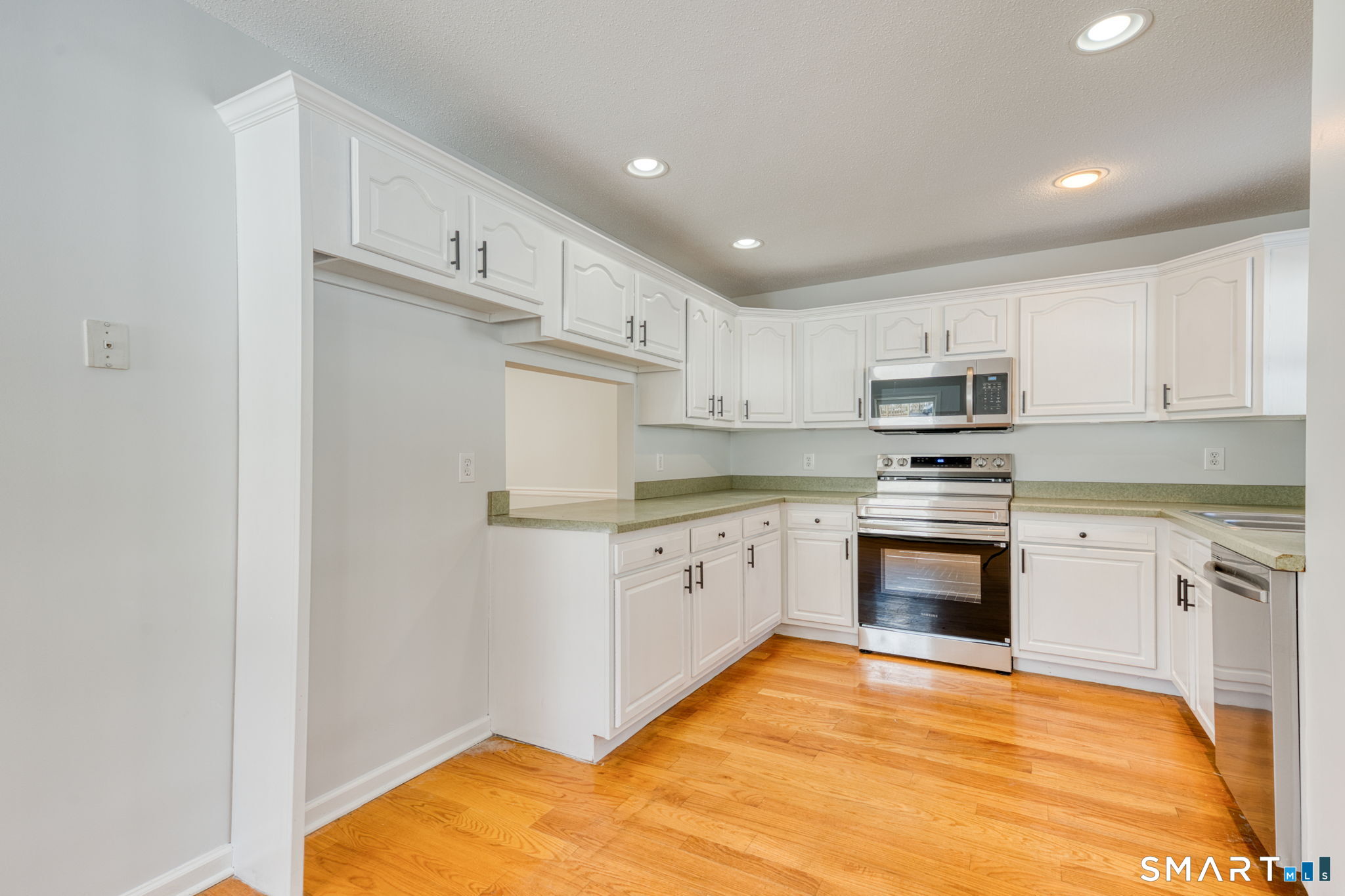 350 Bristol Street, Unit C1 Waterbury, CT 06708 - Photo 24 of 40 a kitchen with granite countertop white cabinets and stainless steel appliances
