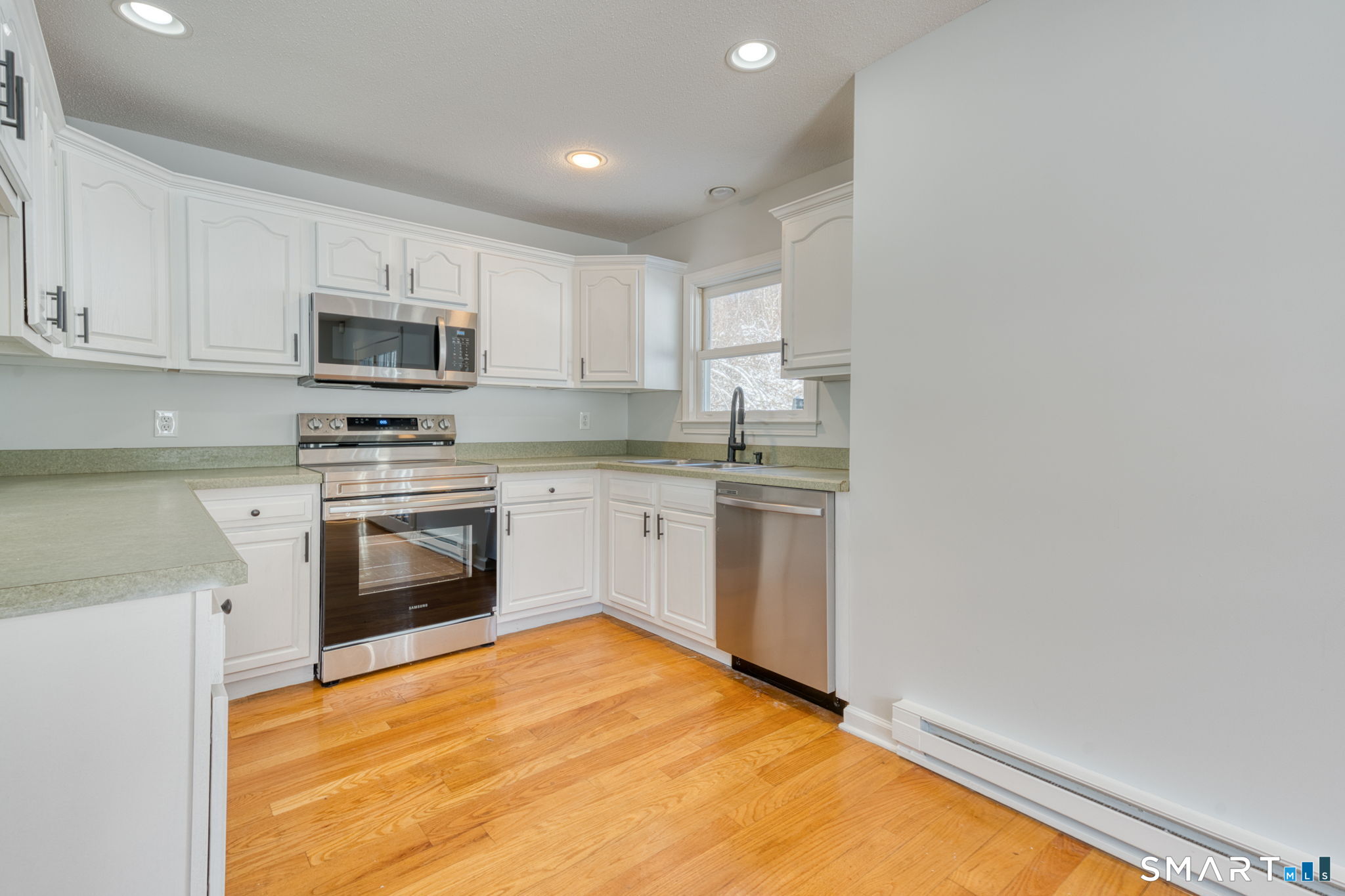 350 Bristol Street, Unit C1 Waterbury, CT 06708 - Photo 26 of 40 a kitchen with stainless steel appliances a white stove top oven sink and cabinets
