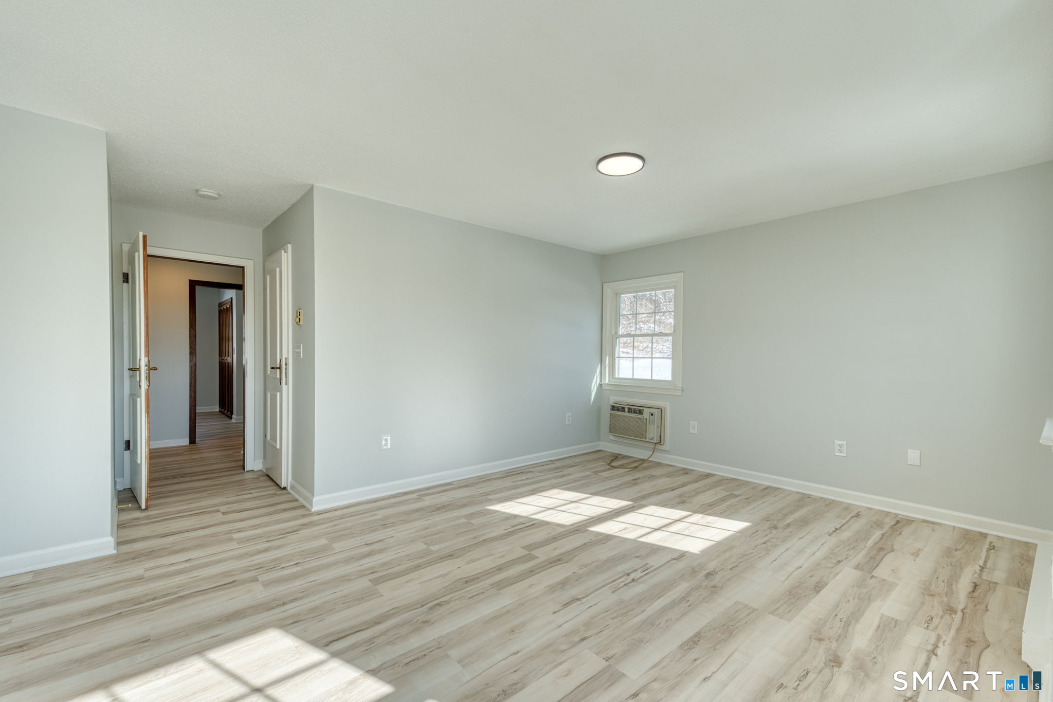 350 Bristol Street, Unit C1 Waterbury, CT 06708 - Photo 35 of 40 an empty room with wooden floor and windows