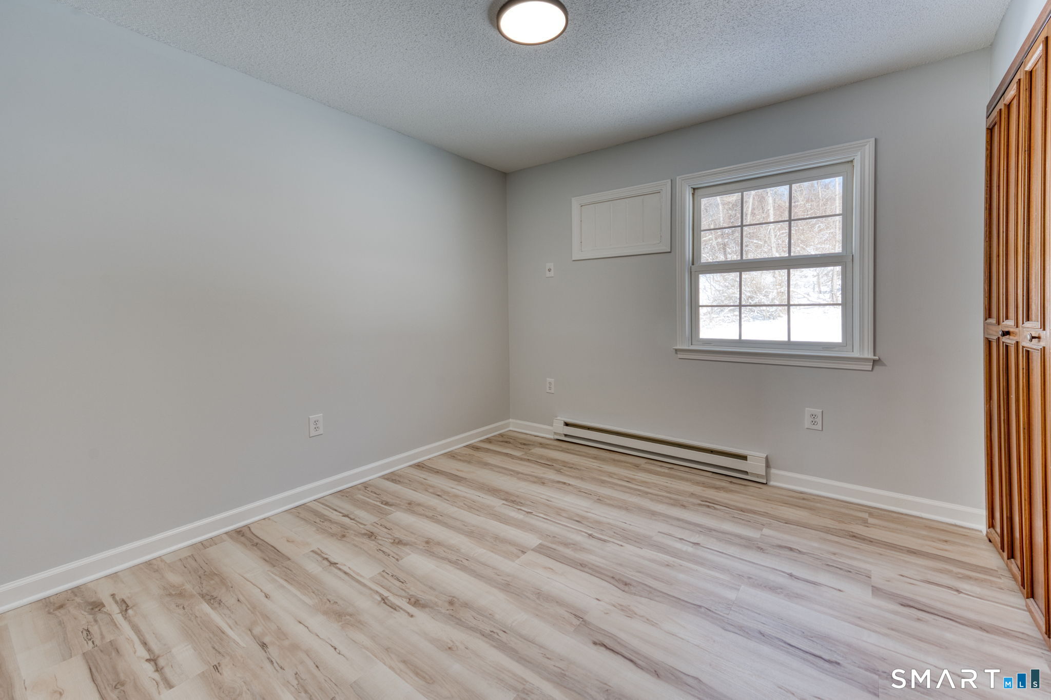 350 Bristol Street, Unit C1 Waterbury, CT 06708 - Photo 36 of 40 an empty room with wooden floor and windows