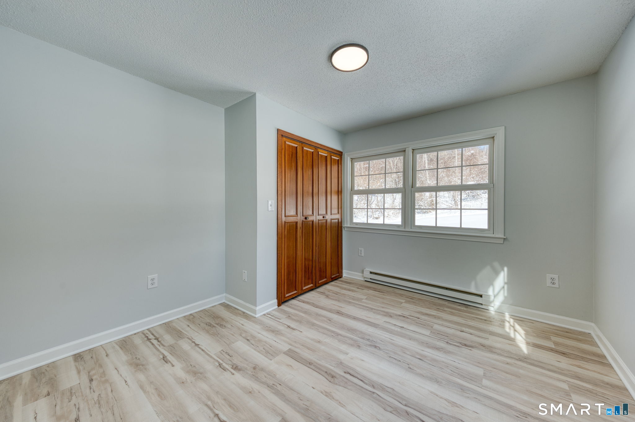 350 Bristol Street, Unit C1 Waterbury, CT 06708 - Photo 39 of 40 an empty room with wooden floor and windows