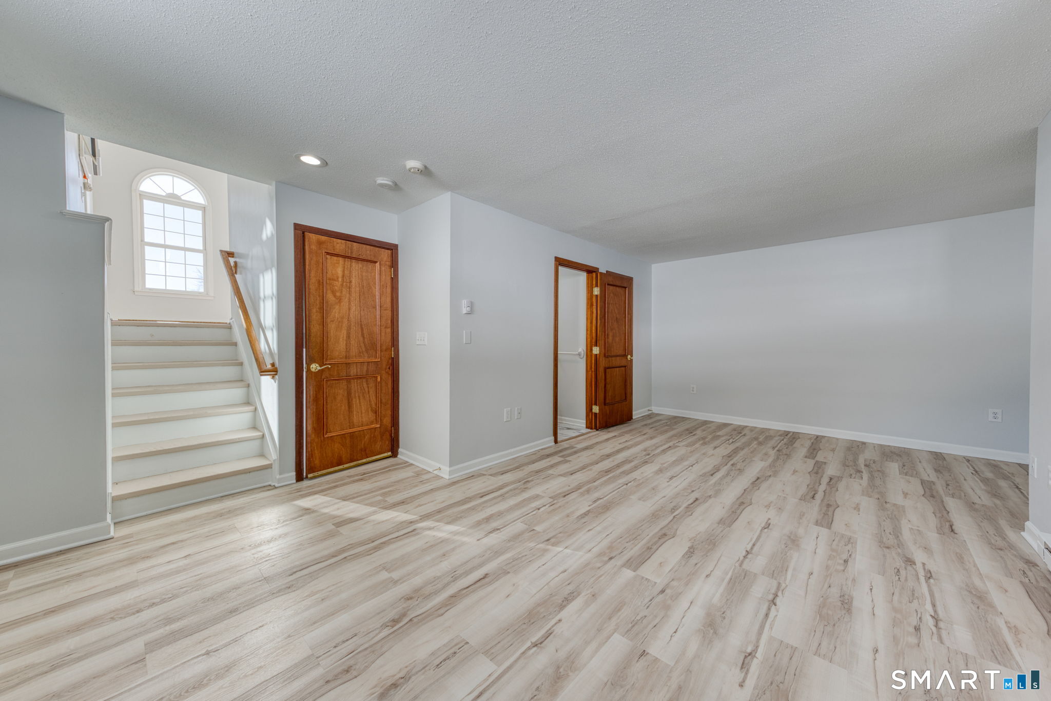 350 Bristol Street, Unit C1 Waterbury, CT 06708 - Photo 5 of 40 a view of an empty room with wooden floor and stairs
