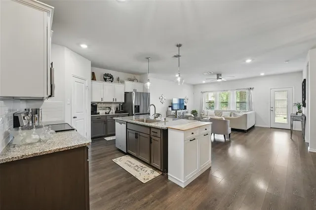 a large kitchen with stainless steel appliances kitchen island granite countertop a large center island and a sink