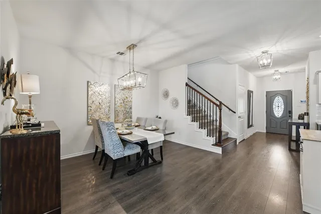 a dining room with furniture a chandelier and wooden floor