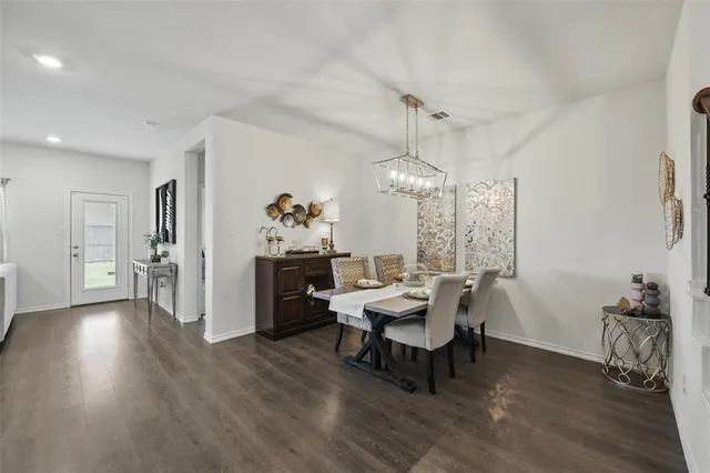 a dining room with furniture a chandelier and wooden floor