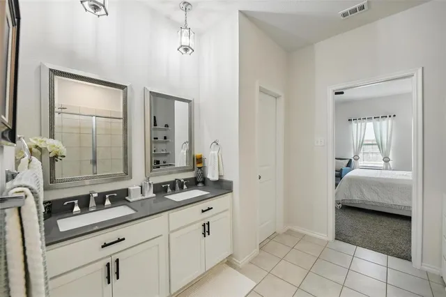 a en suite bathroom with a double sink and mirror