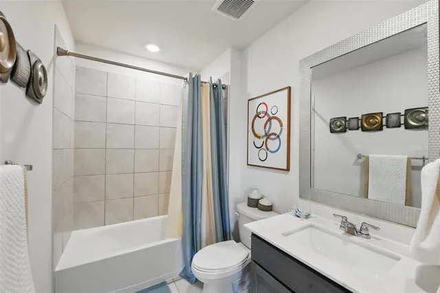 a bathroom with a sink a toilet and a large mirror